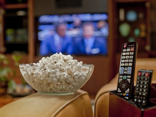 popcorn and remote with tv in background