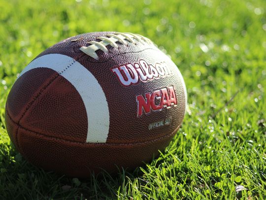 NCAA wilson football laying on grass