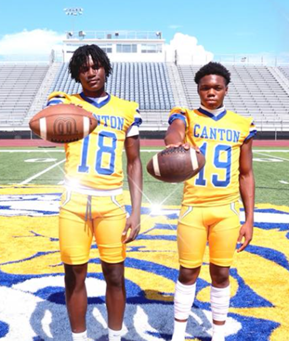 Canton Football Looking for a Bounce Back Season two boys in yellow canton football uniforms standing on football field holding footballs in front of them.