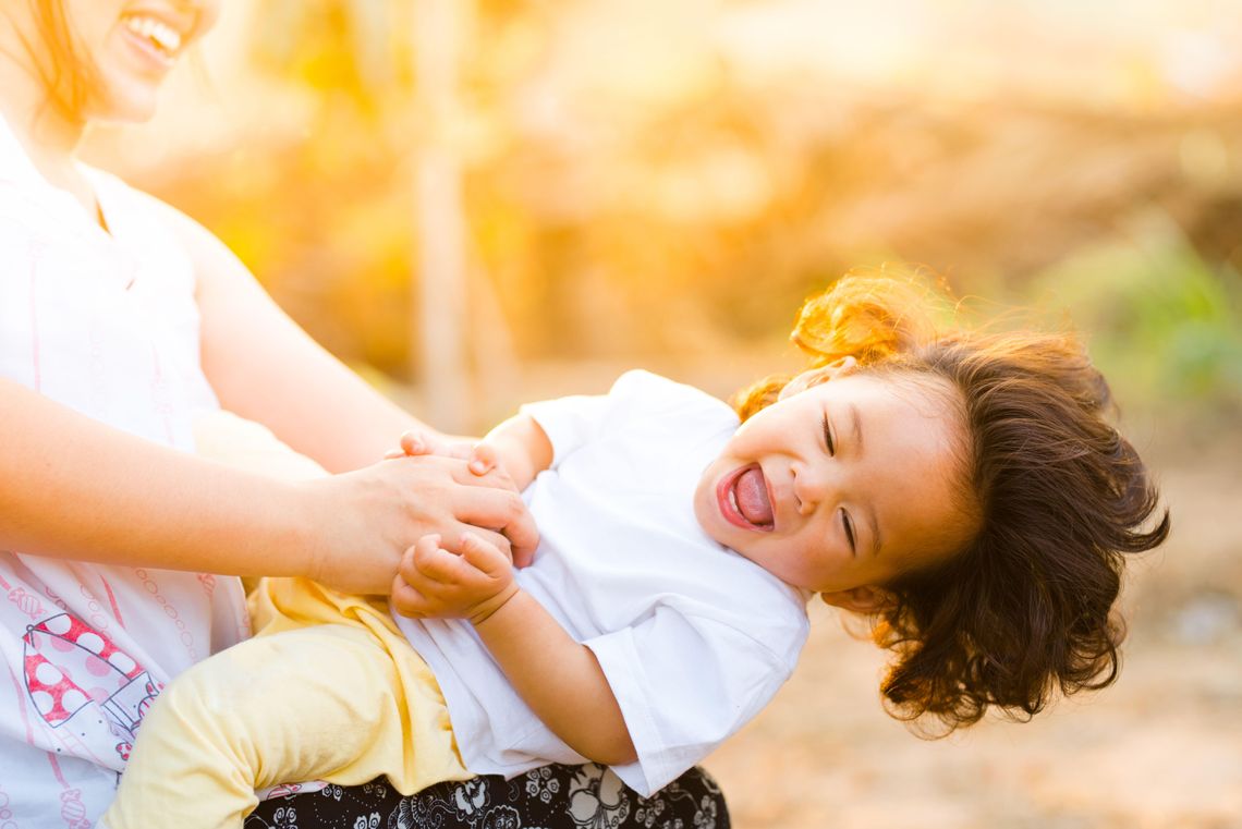 How To Switch Off After A Hard Day: A Guide For Moms woman holding a baby smiling