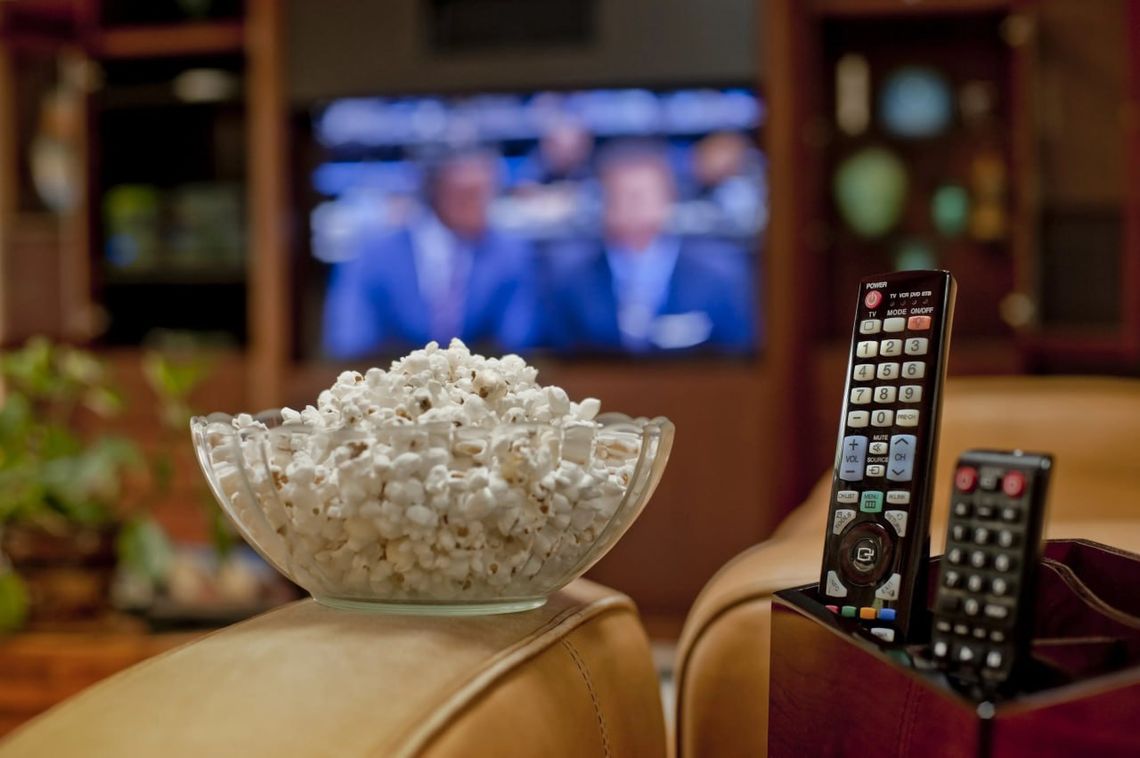 popcorn and remote with tv in background