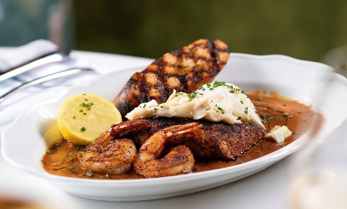 Coraline’s Redfish Court Bouillon is a delectable dish of fresh seafood prepared with New Orleans-inspired flair and flavors.