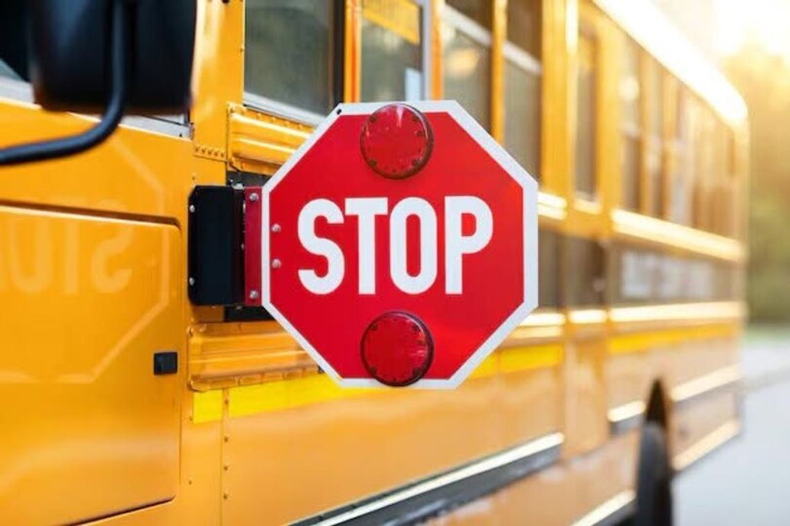 School district reminds drivers to stop for school buses A yellow school bus with its red stop sign extended