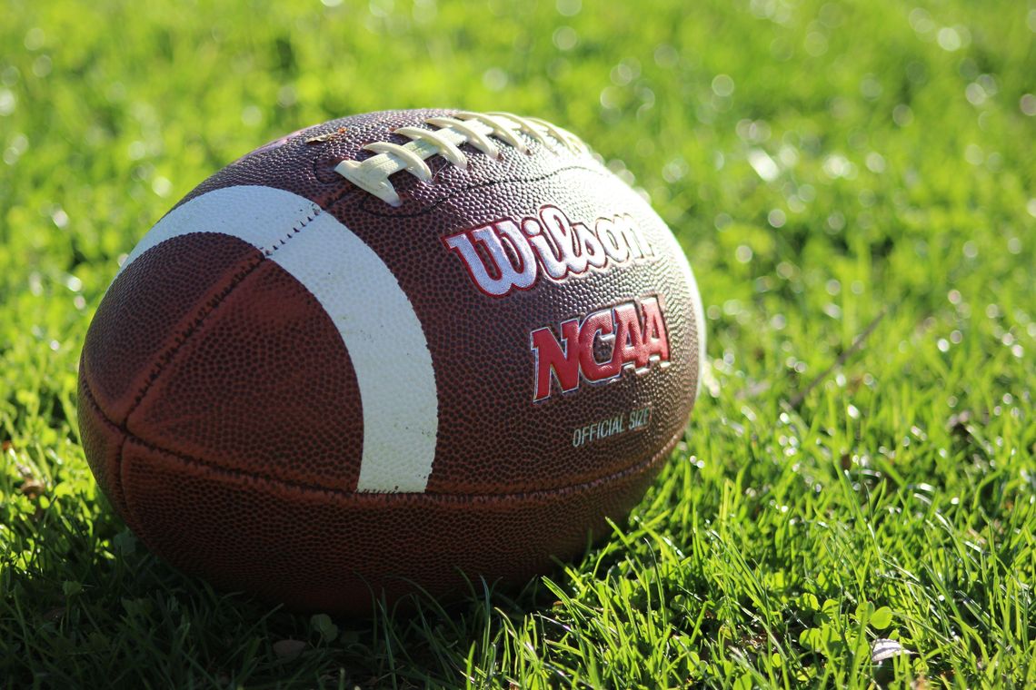 NCAA wilson football laying on grass